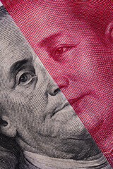 Overlapping fragmentary 100 Chinese yuan and 100 US dollar bills