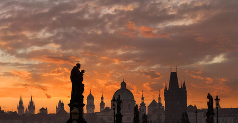 Obraz premium Sunrise over the capital of the Czech Republic - Prague city with silhouettes of buildings and statues