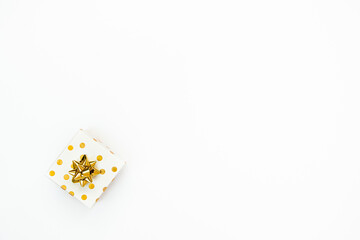 Top view of a golden dotted gift box on a white background. Copy space.