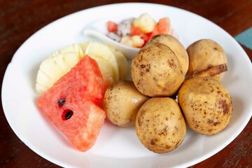 Mixed fruit plate on white brown table