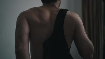 man puts on a corset for posture correction