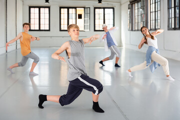 Team of young dancers training street dance moves and having fun