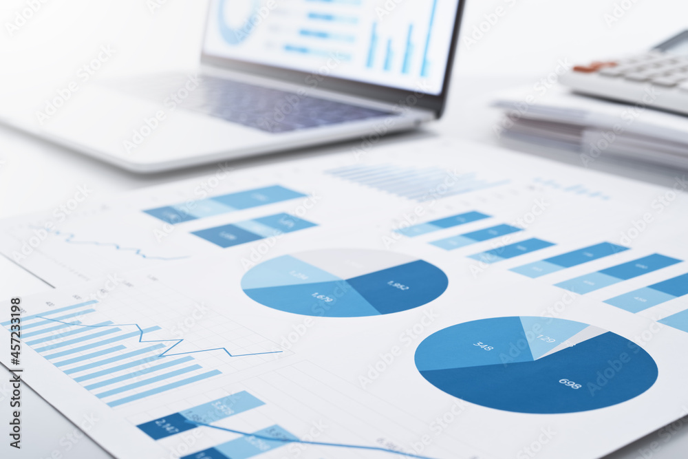 Poster Business intelligence and analysis reports. Many graphs on reports and laptop display.