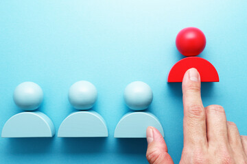Selecting person more suited for the job. Hand pointing red person icon block.