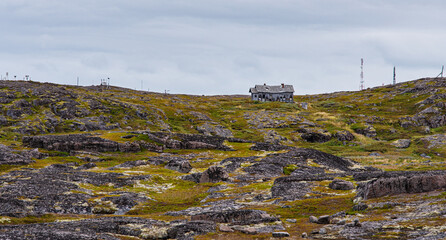 old wooden house on a hill, covered with colorful moss. Teriberka, Barents Sea, Murmansk region, Kola Peninsula