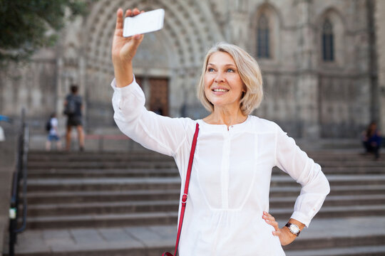 Mature Female Tourist Making Selfie On The Background Of Landmark. High Quality Photo