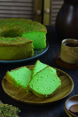 Bolu pandan or Pandan Chiffon Cake, served with tea on dark wooden background. Selective focus.