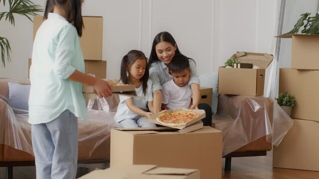 Korean Family Eating Pizza Celebrating Moving To New House