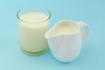 Fresh milk in jug and glass on blue background	