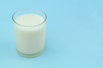 Glass of milk on blue background with room for text