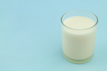 Glass of milk on blue background with room for text	