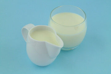 Fresh milk in jug and glass on blue background	