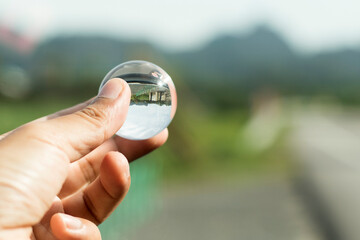 close-up hand holding bright crystal ball isolated natural background