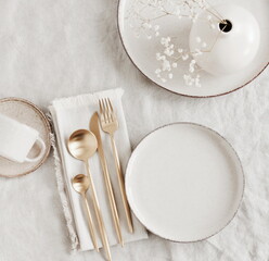 Modern ceramic tableware top view on white linen tablecloth with copy space.  Trendy plates,...