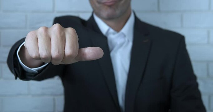 Businessman showing thumbs down. A man with negative emotions show his thumb down in the office.