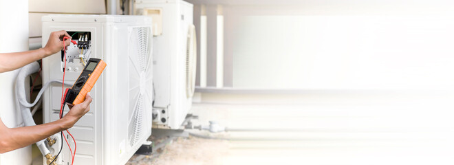 Air conditioner repairman using electricity meter to check air conditioner operation, maintenance concept