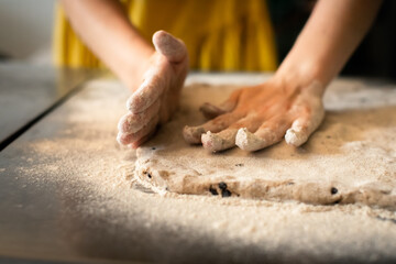 Molding rye sticks with chocolate and hazelnuts by a woman