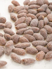 almonds with sweet sprinkles on a plate on a white background