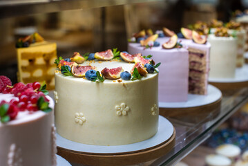 there are a lot of cakes on sale in the window. figs and blueberries bright decor of contide products