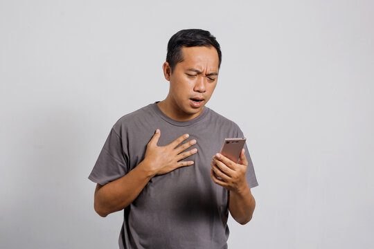 Sad and dissapointed Asian man get bad news from smart phone
