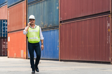 Worker engineer walking to checking the containers box from cargo ship for export and import