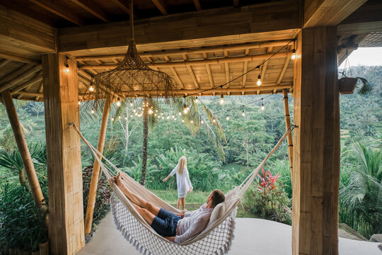 A couple in love sits in a villa in Bali and admires the view of the rice fields