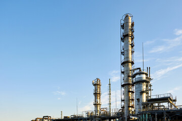 Oil refinery chemical plant wide view with copyspace over blue evening sky with clouds background....