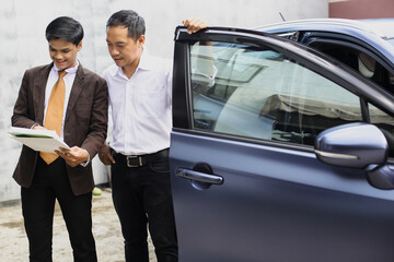 Fototapeta na wymiar Car salesman explaining sales contract to the customer