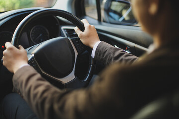 Driver in suit driving a car with hand on the steer