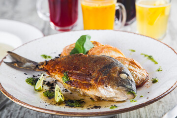 fried dorado on a plate with stewed vegetables sauce