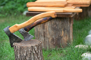 Two new axes on a background of wooden planks. outdoors