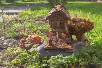A toy homemade house of a fairy-tale creature made of logs and branches in the park
