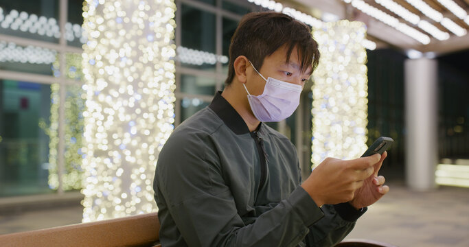 Asian man wear face mask and use of mobile phone at night