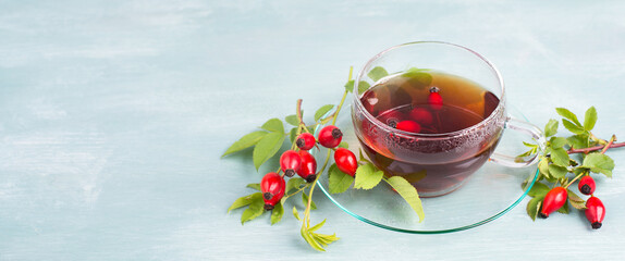 Hip rose tea with fresh fruits and leaves, hot drink