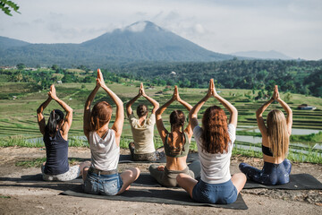 A group of yogis doing yoga, meditating in nature, in the mountains, beautiful view. - obrazy, fototapety, plakaty