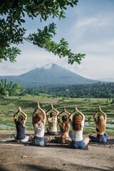 A group of yogis doing yoga, meditating in nature, in the mountains, beautiful view.
