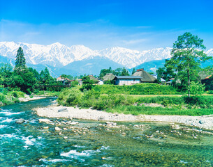 長野県　白馬村　新緑の小川と古民家とアルプス山脈