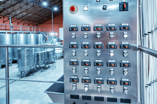 A control panel with toggle switches and indicators of temperature and pressure in tanks and vessels in a modern factory or plant