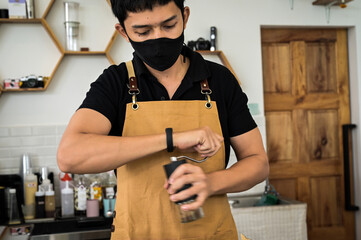 The barista uses a high-quality hand grinder to grind the special coffee beans for the good taste and aroma of the beans.