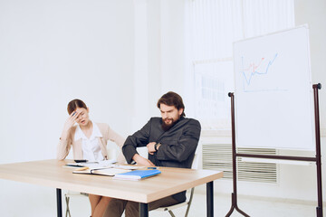 man and woman sitting at a desk office work communication professionals