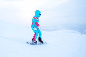 Fototapeta na wymiar woman snowboarder is snowboarding from the slope