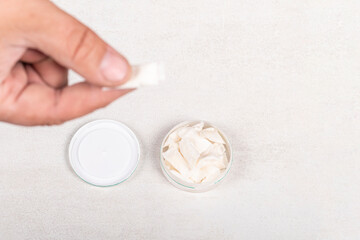 snus. soft focus. the man's hand is in it, tobacco in bags. the background is wooden in a retro style. there is a tinting. close-up.