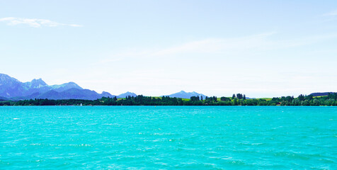 Forggensee near Füssen. Blue lake with surrounding landscape in the Bavarian Allgäu.