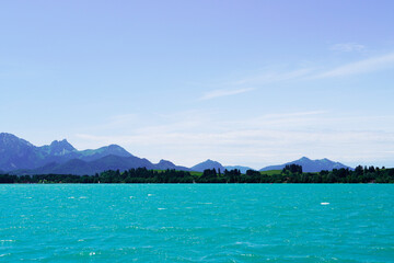 Forggensee near Füssen. Blue lake with surrounding landscape in the Bavarian Allgäu.