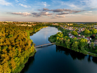 Olsztyn Lake Dlugie, bird's eye view. Wooded shores, the sky reflecting in the water table and a bridge over the lake - Warmia and Masuria, Poland