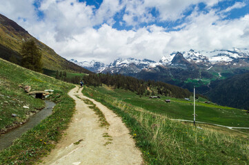 Naklejka na ściany i meble Mountain hiking path along a creek the Ru Curtod in the italian Alps in Valle d'Aosta near Monte Rosa