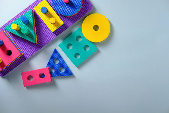 Children's toy on logic in the form of various figures, square, circle, rectangle, triangle on a blue background, top view