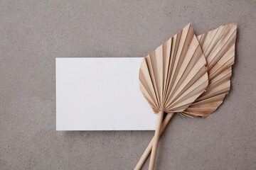 Blank invitation card for a natural wedding or celebration event with dried palm leaf stem