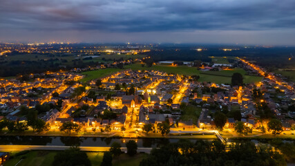 Aerial of a residential area seen from above during a dark grey cloudy sunset in Sint Jozef, Rijkevorsel, Antwerp, Belgium, shot by a drone. High quality photo - obrazy, fototapety, plakaty