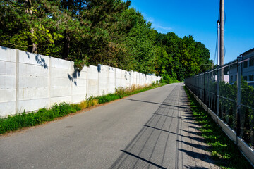 A path with a fence that leads to a nature park near the city for rest, recreation and rejuvenation